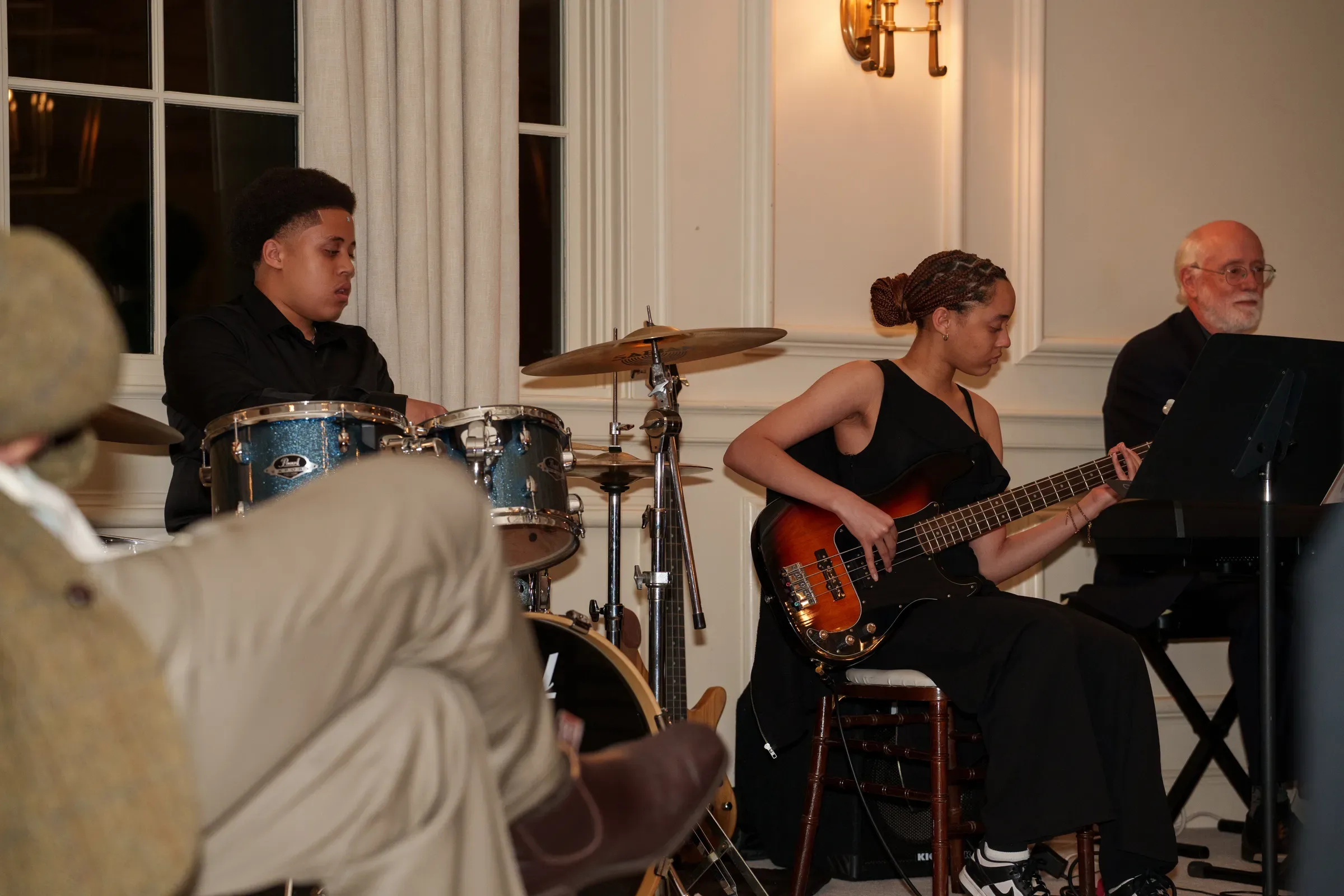 KEYS students playing drums, bass and keyboard at a performance