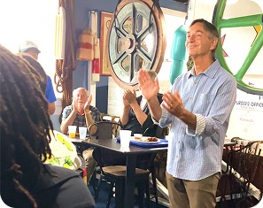 Rob Silvan clapping with a group of community supporters
